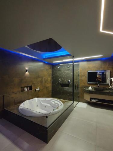 a large bath tub in a bathroom with a tv at Prestige Motel 3 in Sorocaba