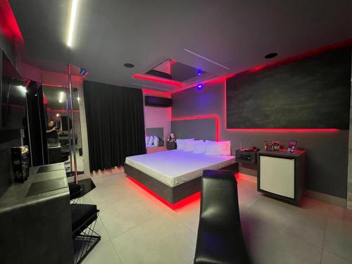Prestige Motel 3 في سوروكابا: غرفة نوم بسرير كبير مع انارة حمراء