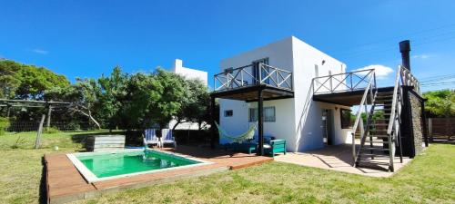 una villa con piscina e una casa di GreyStone a Balneario Buenos Aires