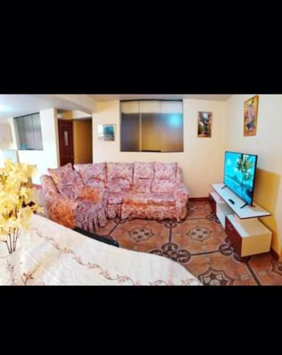 sala de estar con sofá y TV de pantalla plana en Home Dreams Cusco, en Cusco