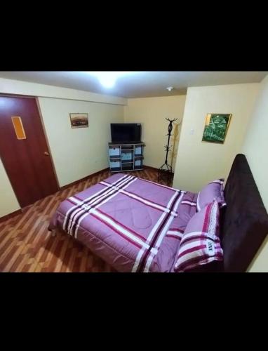 1 dormitorio con 1 cama grande y TV en Home Dreams Cusco, en Cusco