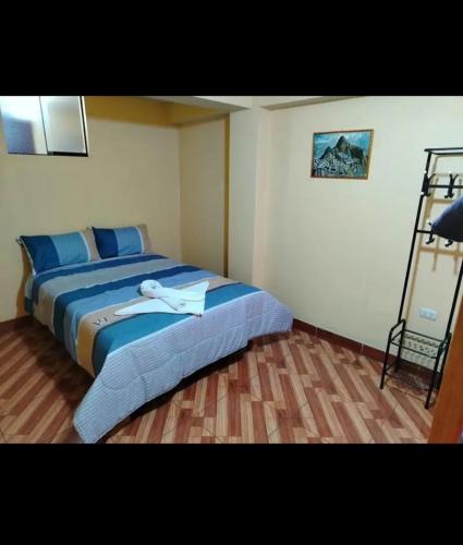 a bedroom with a bed with a white robe on it at Home Dreams Cusco in Cusco