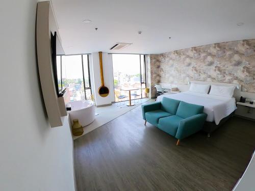 a large bedroom with a bed and a blue couch at Hotel Black Tower Premium in Bogotá