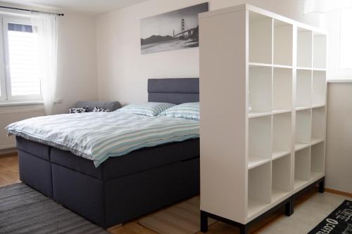 a bedroom with a bed with white shelves at Apartmán U Onky in Luhačovice