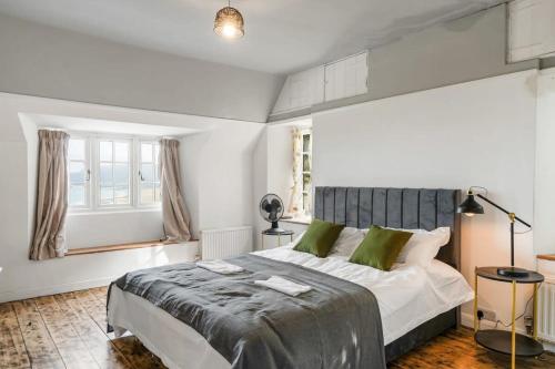 a bedroom with a large bed and a window at Secluded Cottage w Expansive Sea Views & Garden in Culbone