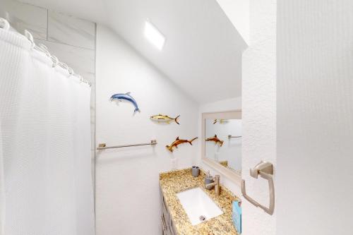 a bathroom with a sink and two fish on the wall at Overseas Beauty in Marathon