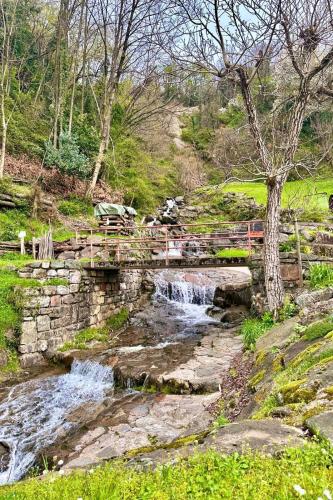 a bridge over a river with a waterfall at Casa Emma in Porto Ceresio