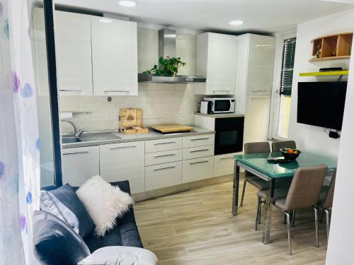 eine Küche mit weißen Schränken und einem Tisch mit einem Sofa in der Unterkunft Casa Emma in Porto Ceresio