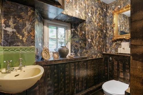 a bathroom with a sink and a toilet at Secluded Cottage w Expansive Sea Views & Garden in Culbone