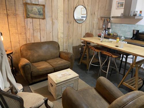 a living room with a table and a chair and a table and a couch at Maison de pêcheur Valentine à Trouville in Trouville-sur-Mer
