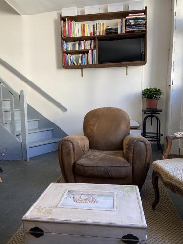 un salon avec une chaise et une télévision dans l'établissement Maison de pêcheur Valentine à Trouville, à Trouville-sur-Mer