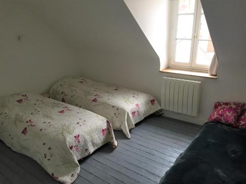 Duas camas num quarto com uma janela em Maison de pêcheur Valentine à Trouville em Trouville-sur-Mer
