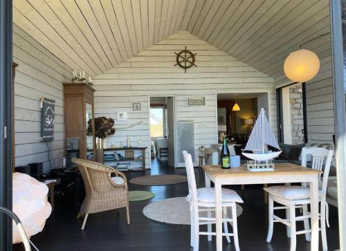 une salle à manger avec une table et des chaises dans l'établissement Résidence P38-ile Grande - Ty Pacha Vue mer Wifi jardin et parking, dépaysement à Ile Grande MAE-6094, à Pleumeur-Bodou