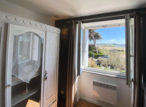 Cette chambre dispose d'une fenêtre et d'une commode avec un miroir. dans l'établissement Résidence P38-ile Grande - Ty Pacha Vue mer Wifi jardin et parking, dépaysement à Ile Grande MAE-6094, à Pleumeur-Bodou