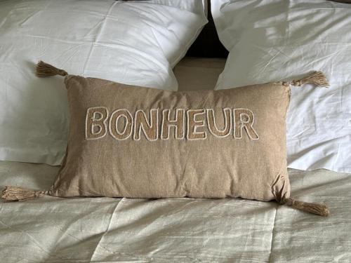 un oreiller avec le mot bourbon écrit dessus sur un lit dans l'établissement Maison indépendante 4 chambres proche Chartres et Rambouillet, à Ymeray