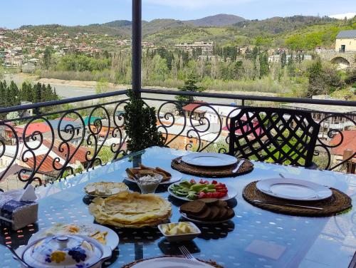 une table bleue avec de la nourriture au-dessus d'un balcon dans l'établissement Veranda Boutique Hotel Kutaisi, à Koutaïssi