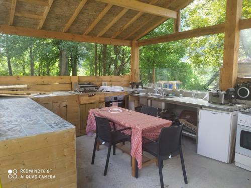une cuisine avec une table et des chaises dans une cabine dans l'établissement La Bergerie du Clot, à Val-de-Chalvagne