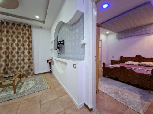 a living room with a bed and a stairway to a bedroom at Résidence Karim in Djerba