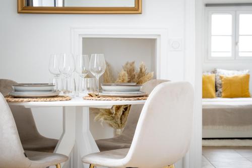 a white dining room table with wine glasses on it at L'Orangerie Versaillaise - À 2 pas du Château de Versailles in Versailles