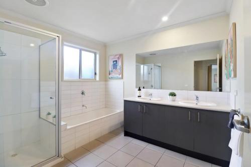 a bathroom with two sinks and a shower and a tub at Reconnect on Daly I Epworth and Deakin in Geelong