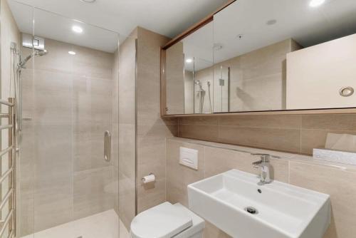 La salle de bains est pourvue de toilettes, d'un lavabo et d'une douche. dans l'établissement Te Awa at La Residence du Parc, à Queenstown