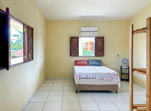 una camera da letto con un letto e una finestra di Casa com piscina a 350m da Praia do Croa Alagoas a Barra de Santo Antônio