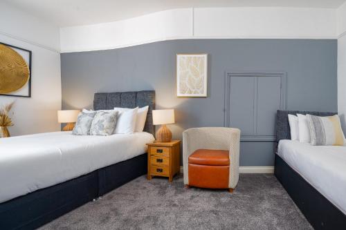 a room with two beds and a chair in it at Boars Head Hotel in Carmarthen