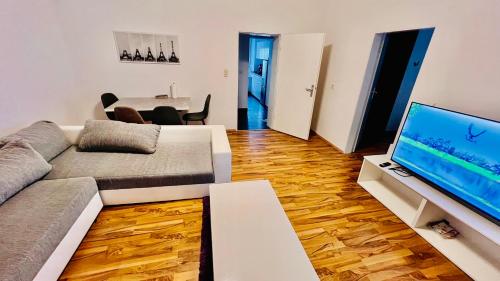 a living room with a couch and a flat screen tv at DE Apartment in Neu Ulm