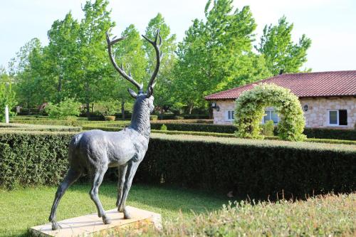 a statue of a deer with large antlers in a garden at The Estate of Thebes in Loukísia
