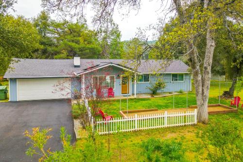 a blue house with a white fence in the yard at Dog-Friendly Oakhurst Home Walk to Downtown! in Oakhurst