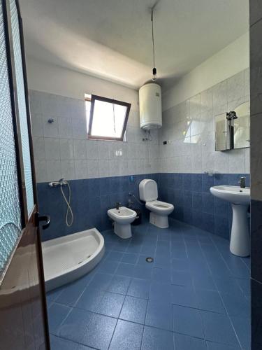 a bathroom with two toilets and a tub and a sink at Shabani in Tirana