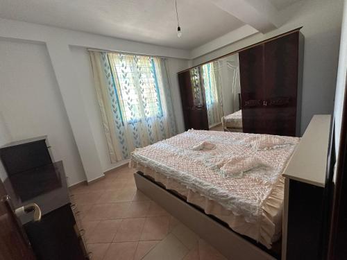 a bedroom with a bed and a large window at Shabani in Tirana