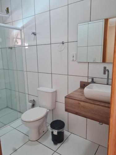 uma casa de banho com um WC, um lavatório e um espelho. em Rancho da Malu em Taubaté