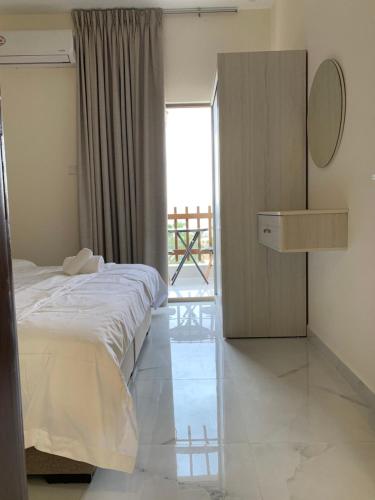 ein Schlafzimmer mit einem Bett, einer Kommode und einem Fenster in der Unterkunft Salma Suites in Aqaba