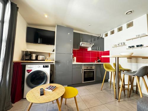 une cuisine avec une machine à laver et une table dans l'établissement Le Cocon Citadin - Parking Gratuit à 500 m - 2 Smart TV, à Avignon