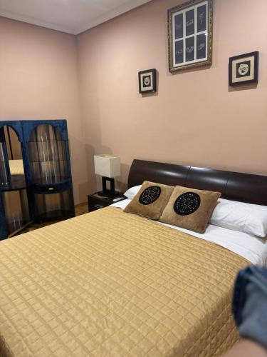 Un dormitorio con una cama con dos almohadas encima. en El escondite Verona, en Tomelloso