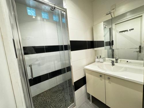 une salle de bain avec une douche en verre et un lavabo dans l'établissement Le Cocon Citadin - Parking Gratuit à 500 m - 2 Smart TV, à Avignon