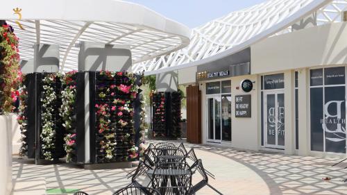 a shopping mall with a bunch of plants and flowers at ZenDen 1BR -Serene Zen-Inspired Stay in Oasis Masdar, Near Masdar Park in Abu Dhabi