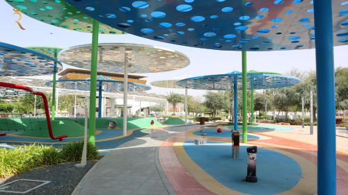 an image of a playground with umbrellas at ZenDen 1BR -Serene Zen-Inspired Stay in Oasis Masdar, Near Masdar Park in Abu Dhabi