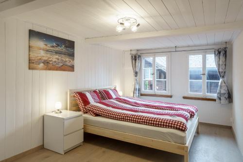 布里恩茨的住宿－Grosses Apartment am schönen Brienzersee，一间卧室配有一张带红白毯子的床