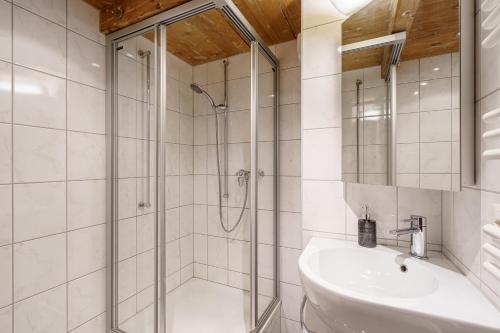 uma casa de banho com um chuveiro e um lavatório. em Grosses Apartment am schönen Brienzersee em Brienz