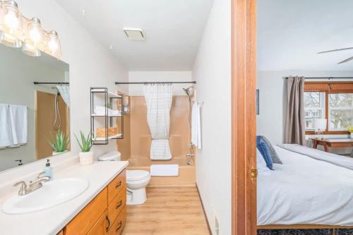 a bathroom with a sink and a toilet and a bed at Relax on Ridgeview- 3 bedroom in Appleton