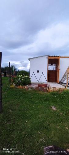 a white building with a door in a yard at Glamping Mafer 4 Tipi pequeño in Guatavita