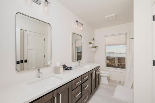 a bathroom with a sink and a mirror and a toilet at Sunset Retreat Lakeside Vacation Home 