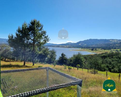 a view of a body of water from a field at Glamping Mafer 4 Tipi pequeño in Guatavita