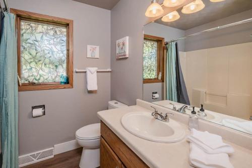 a bathroom with a sink and a toilet and a window at Pine in Appleton
