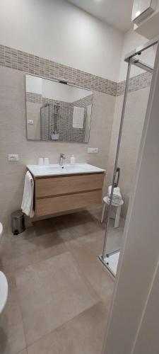 a bathroom with a sink and a mirror at MariGarda Apartments in Assenza di Brenzone