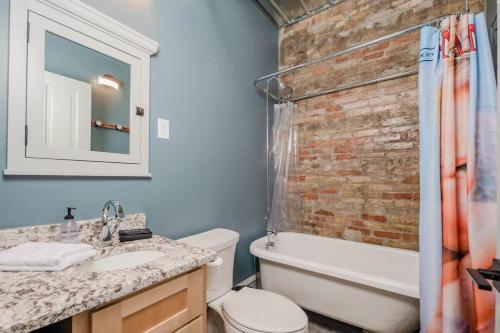 a bathroom with a sink and a brick wall at ᴘɪɴʙᴀʟʟ ᴘᴇɴᴛʜᴏᴜꜱᴇ in Appleton