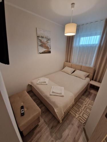 a small bedroom with a bed and a table at Apartament Pisz in Pisz