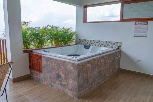 a large bath tub in a room with a window at Acantos Hotel Campestre in Támesis